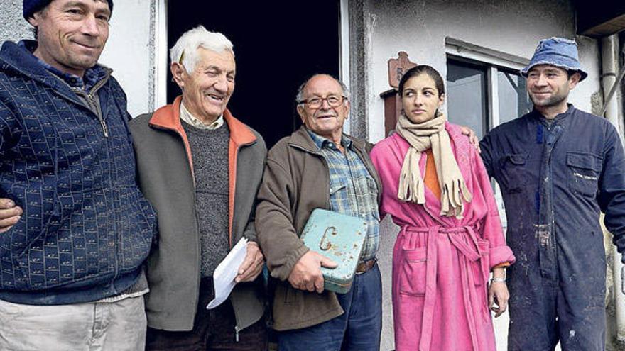 Dos de los vecinos que promueven la colecta (centro), con miembros de la familia rumana.  // Brais Lorenzo