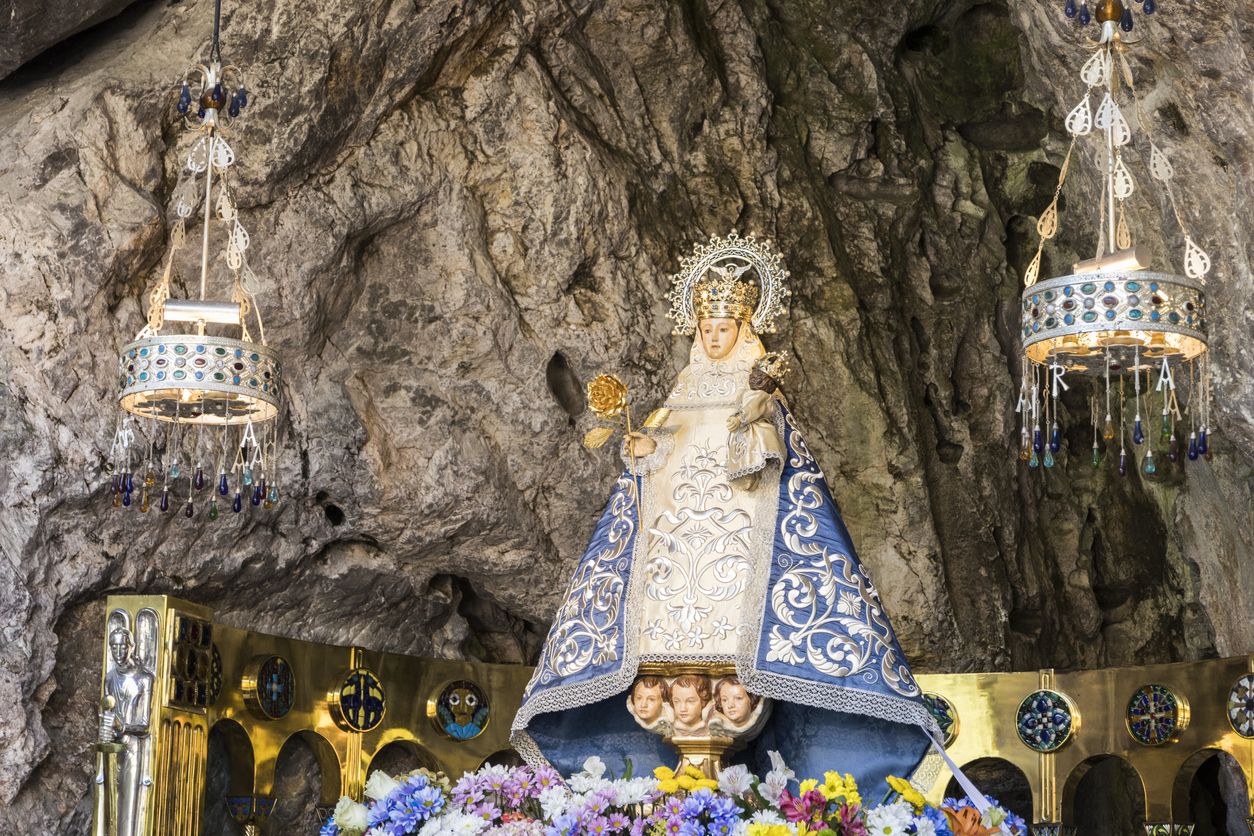 En sus manos, la Santina sostiene al niño Jesús y una rosa dorada