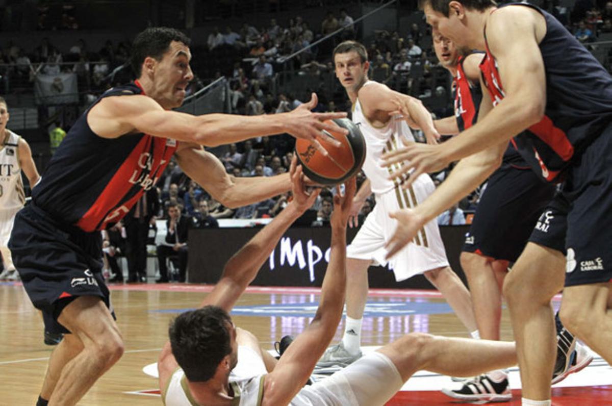El pivot eslovè del Reial Madrid, Mirza Begic, lluita per la pilota amb el base argentí del Caja Laboral, Pablo Prigioni (esquerra), durant el primer partit de les semifinals de la Lliga ACB de bàsquet, a Madrid.