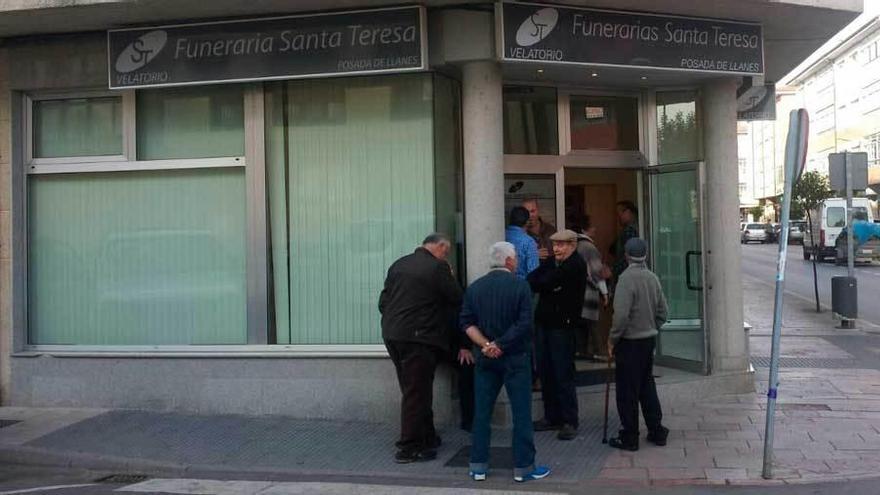 Vecinos del concejo llanisco, ayer, a las puertas del tanatorio, en Posada.