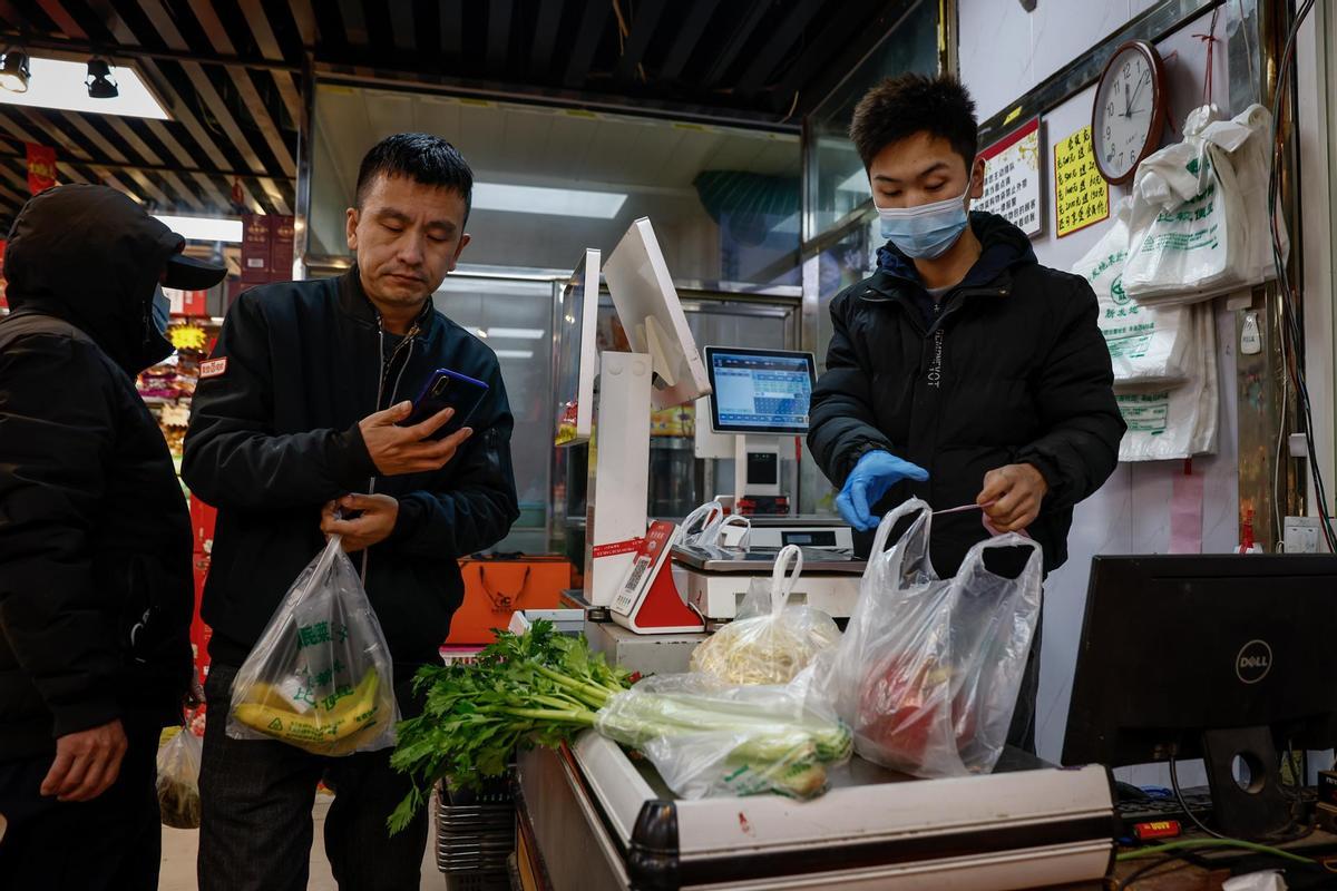 Ciudadanos china hacen fila para pagar en una tienda de Pekín (China) el martes 17 de enero