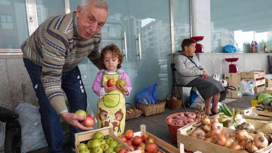 Amador Molleda, con su nieto Manuel Parajón, ayer, en el mercado de la Pola.