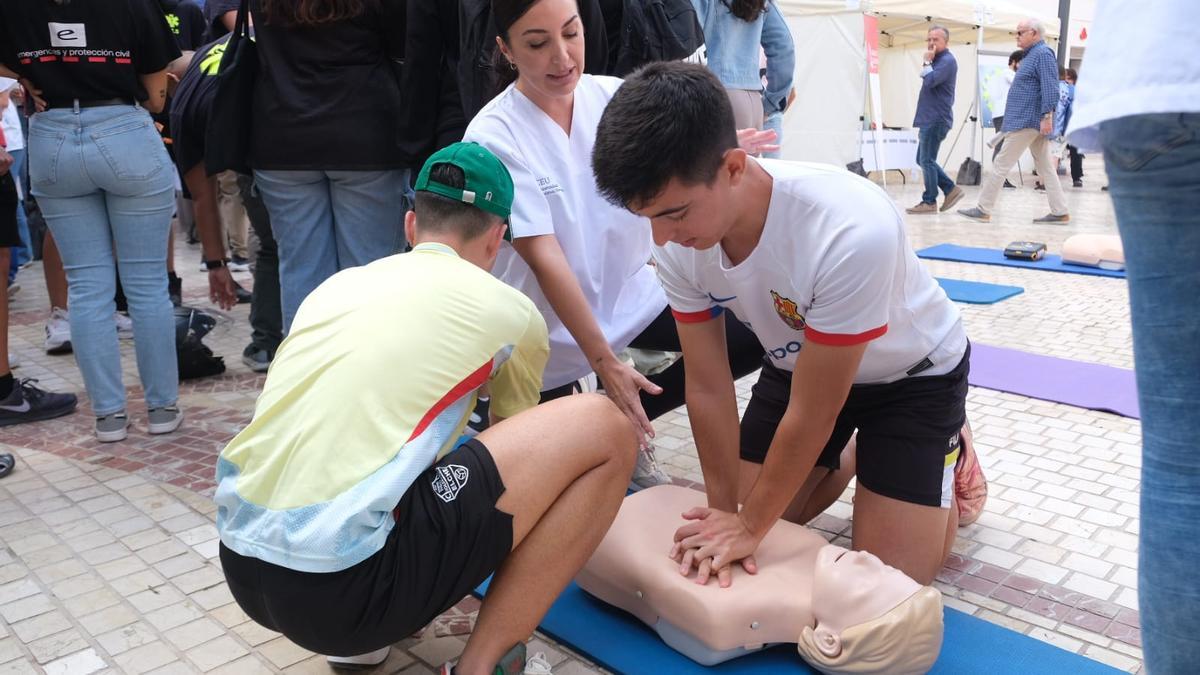 Dos jóvenes aprenden la maniobra de reanimación cardiopulmonar