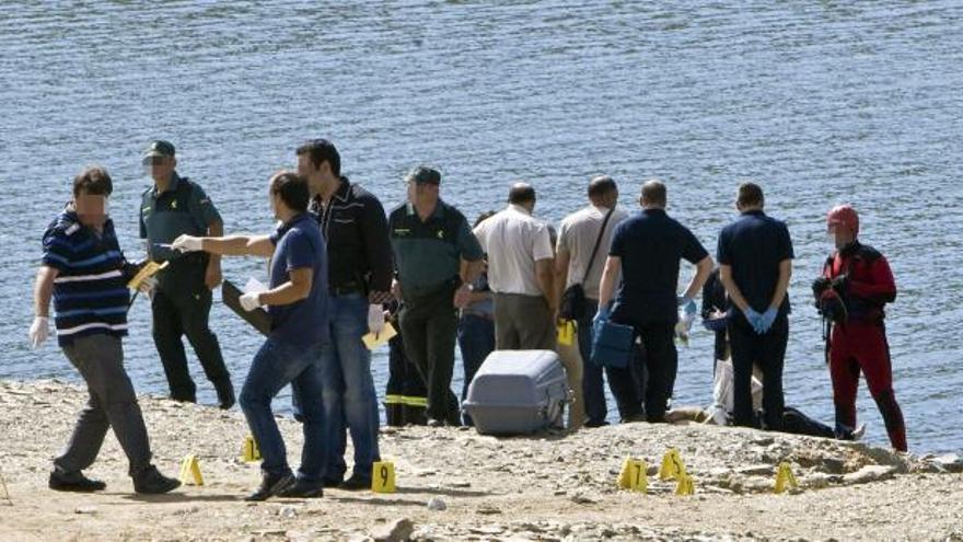 Bomberos y Guardia Civil tras el rescate del asesinado, que aparece tumbado.