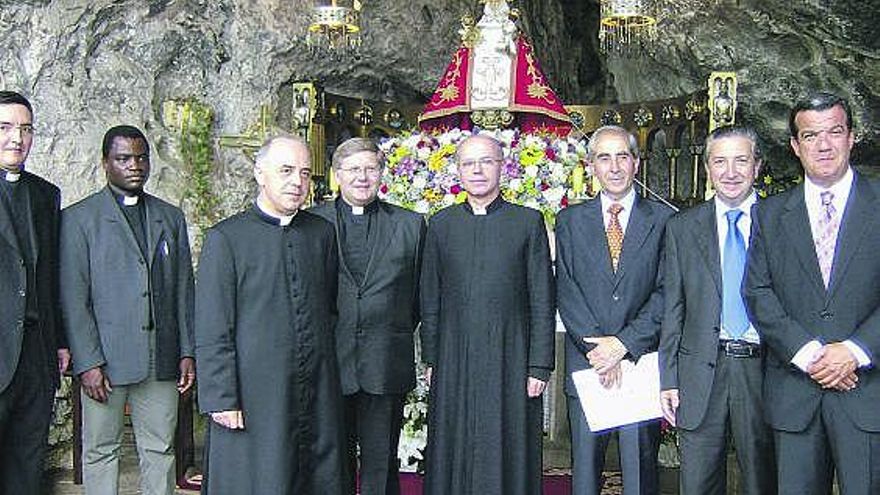 Tuñón, tercero por la izquierda, junto a otros sacerdotes y con los responsables del negocio hotelero, en la santa cueva.