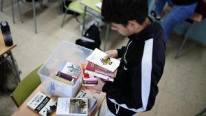 Un alumno de primero de Bachillerato mira los títulos de una de las cajas de lectura de su clase, este curso.