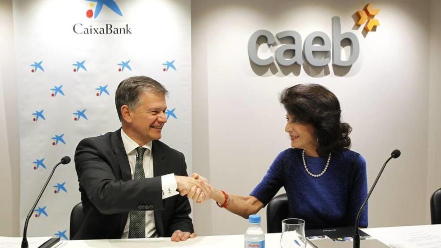 Xicu Costa y Carmen Planas se estrechan la mano tras la firma del acuerdo en la sede de CAEB.