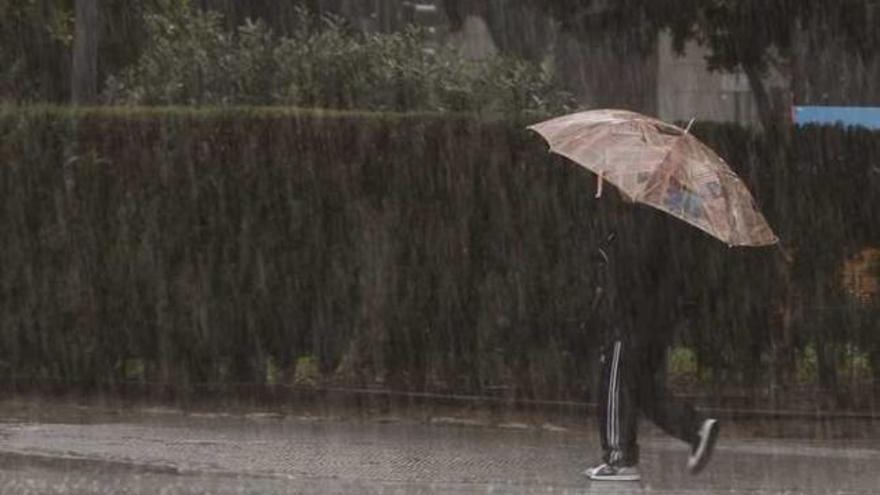 Un transeúnte pasea bajo la intensa lluvia caída ayer en Valencia.