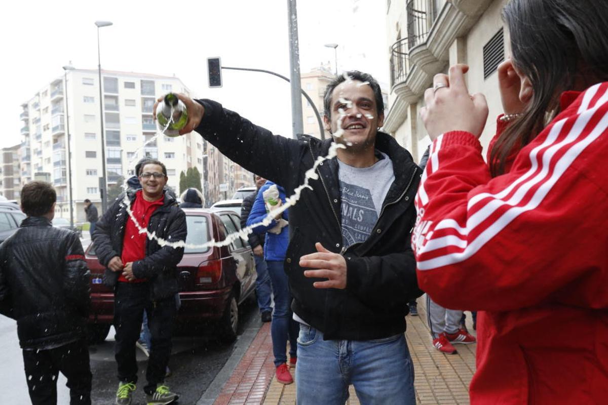 Un hombre celebra con una botella de champagne que le ha tocado 'El Gordo de la Lotería' en Salamanca.
