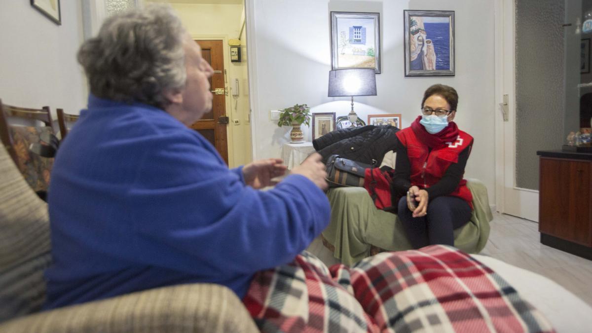 Una voluntaria de Cruz Roja acompaña a una mujer mayor de la provincia