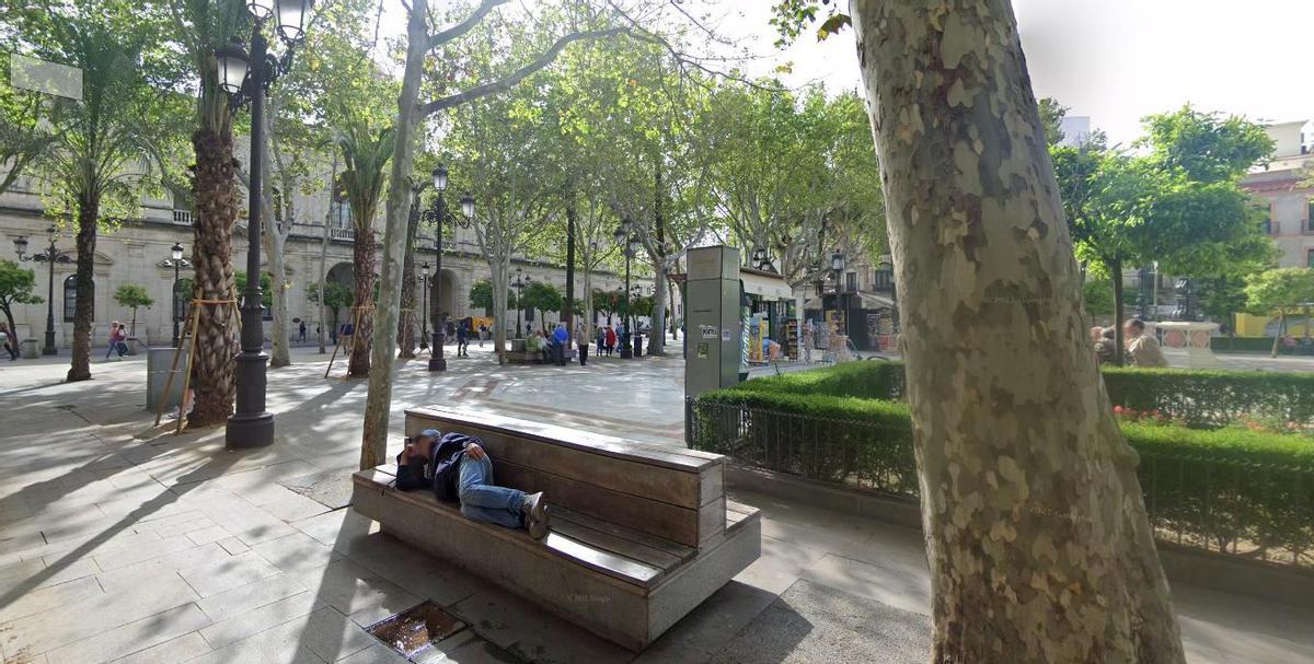 Persona tumbada en un banco de la Plaza Nueva