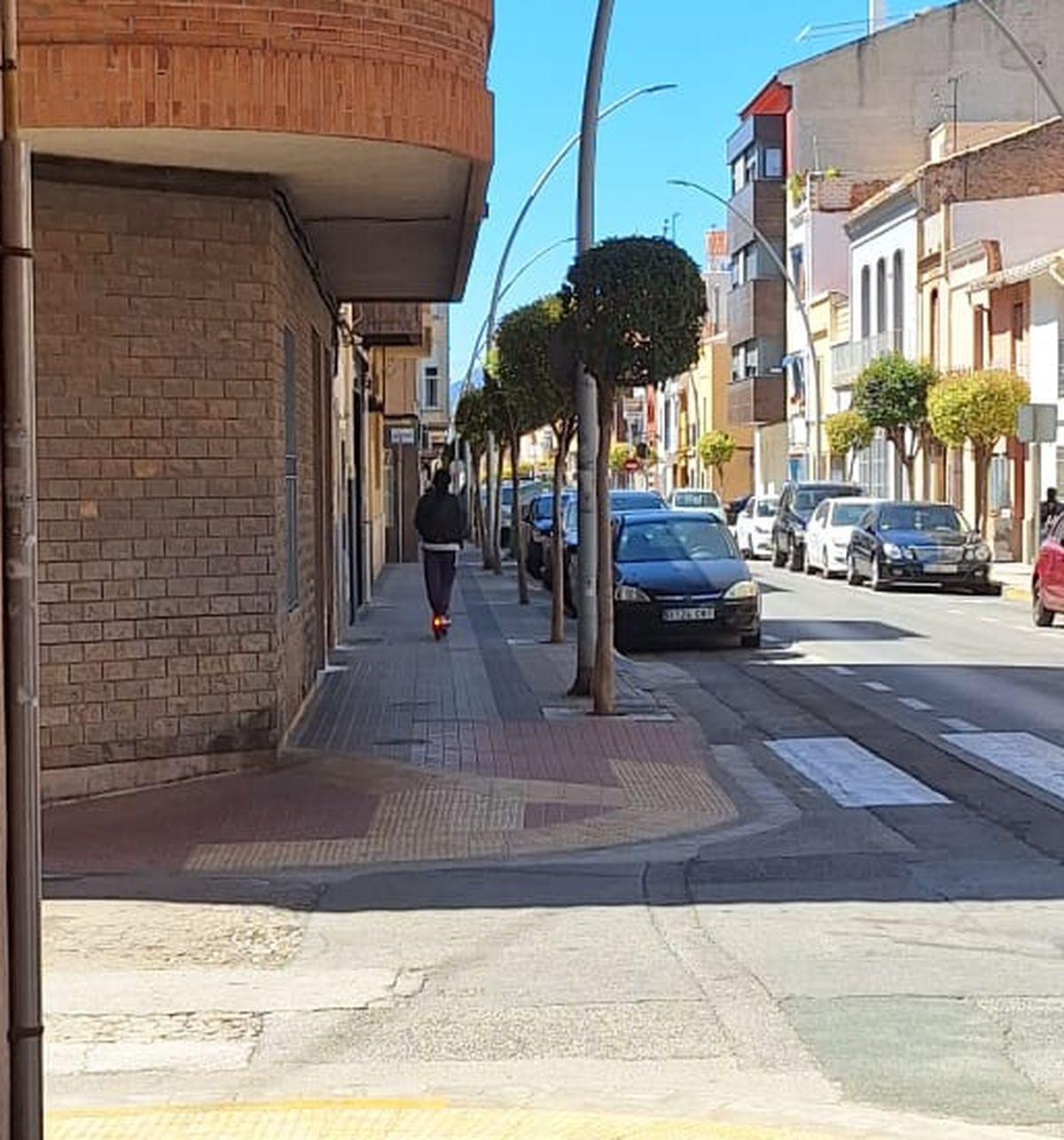 Un usuario de patinete eléctrico circulando por la acera en la calle Joan Baptista Llorens, algo especialmente prohibido por la normativa.
