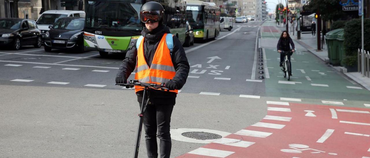 Usuarios del carril bici en bicicleta y patinete eléctrico a su paso  por la calle Venezuela