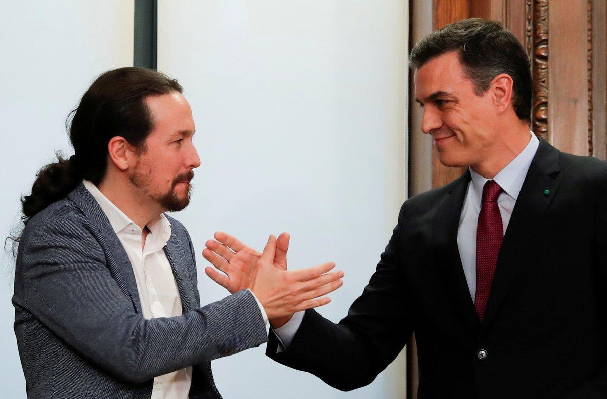 FILE PHOTO: Spain’s acting Prime Minister Pedro Sanchez and Unidas Podemos (Together We Can) leader Pablo Iglesias shake hands as they present their coalition agreement at Spain’s Parliament in Madrid, Spain, December 30, 2019. REUTERS/Susana Vera/File Photo