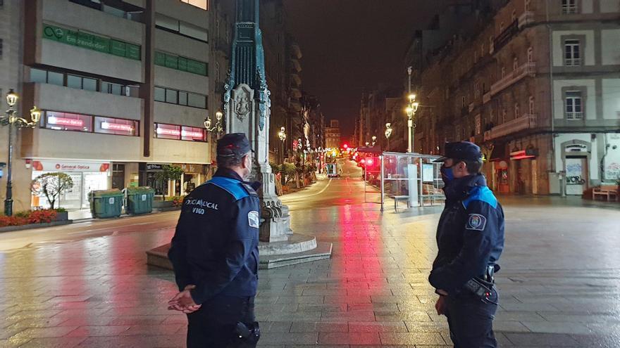 Dos policías patrullan por el centro de Vigo tras el cierre perimetral de la ciudad.