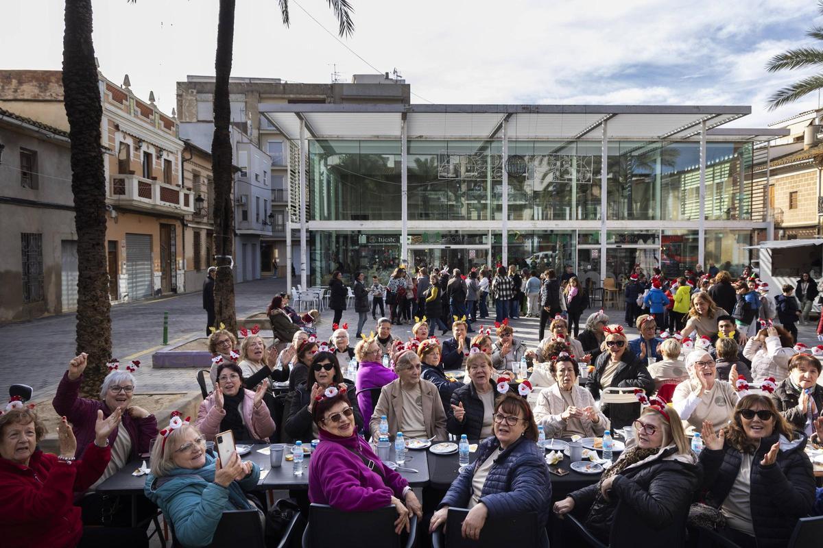Las mujeres congregadas por la escuela de baile Impuls, de Yolanda, almuerzan en el mercado de Paiporta