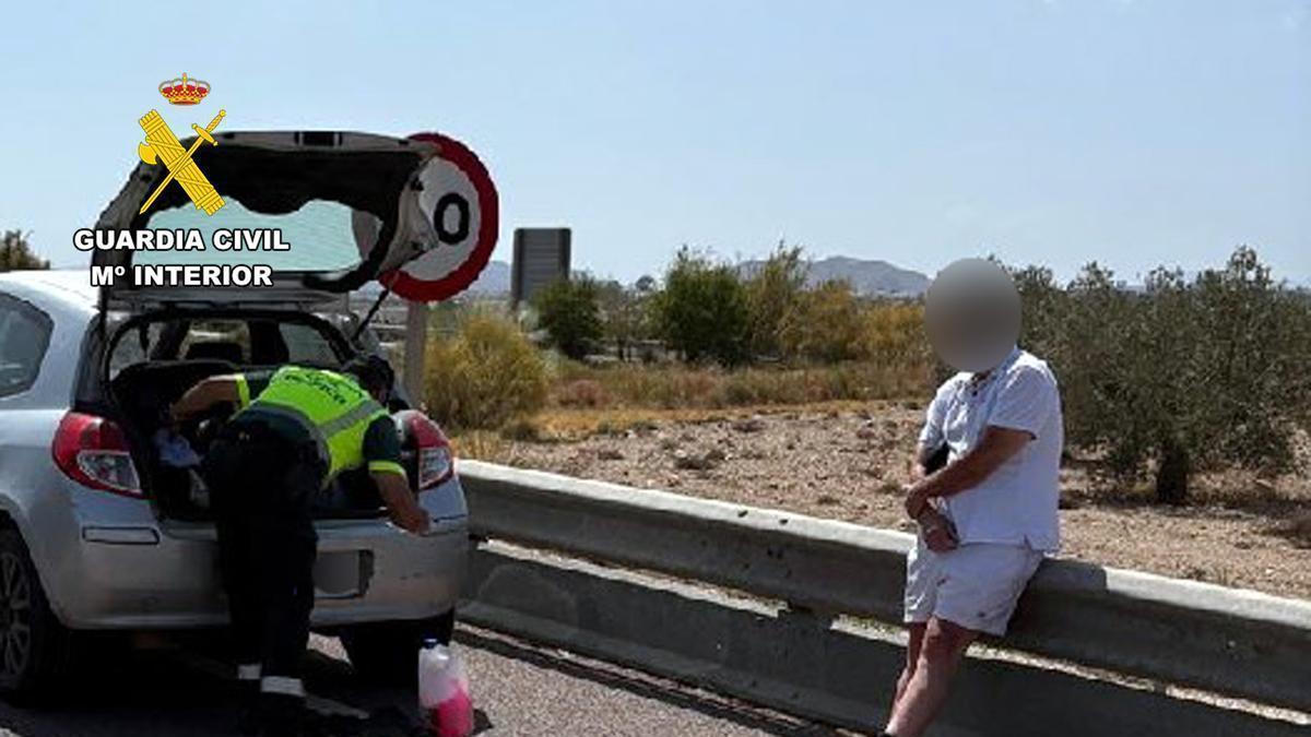 Un agente de la Guardia Civil revisa el coche del detenido.