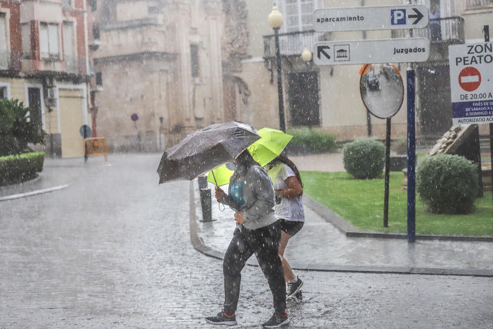 Un buen chaparrón ha sorprendido a primera hora a los peatones en el centro histórico de Orihuela. Las lluvias y tormentas se prolongarán esta tarde con posibilidad de granizo.