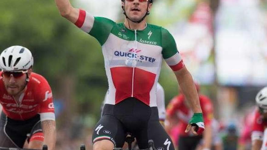 Elia Viviani celebra, levantando su brazo derecho, el triunfo de etapa.