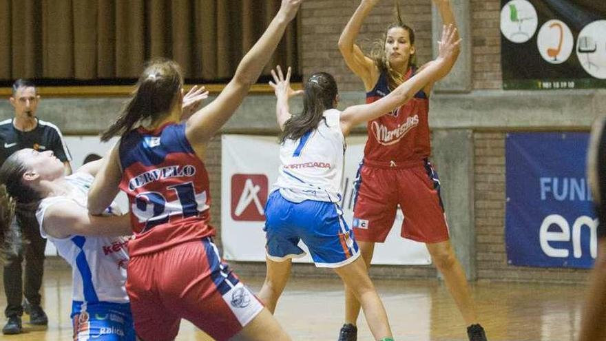 Gema Pazos intenta pasarle la pelota a Laura Cervelo en el partido contra el Cortegada.