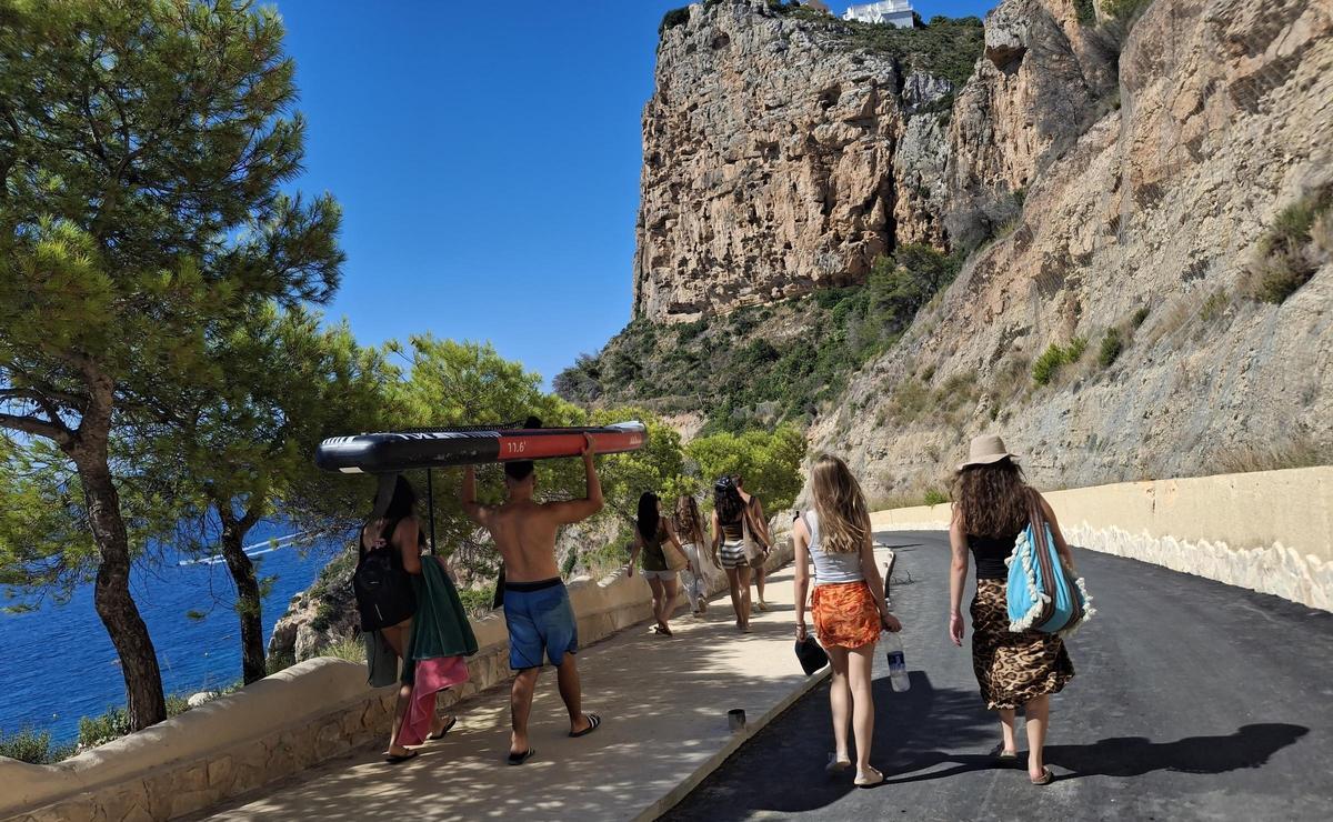 Otro bañista que lleva a cuestas la tabla de paddle surf