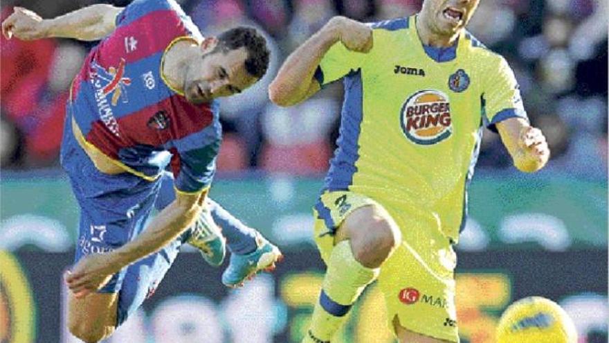 El defensa del Levante UD Juanfran despeja el balón de forma acrobática ante la presencia del delantero del Getafe Miku.