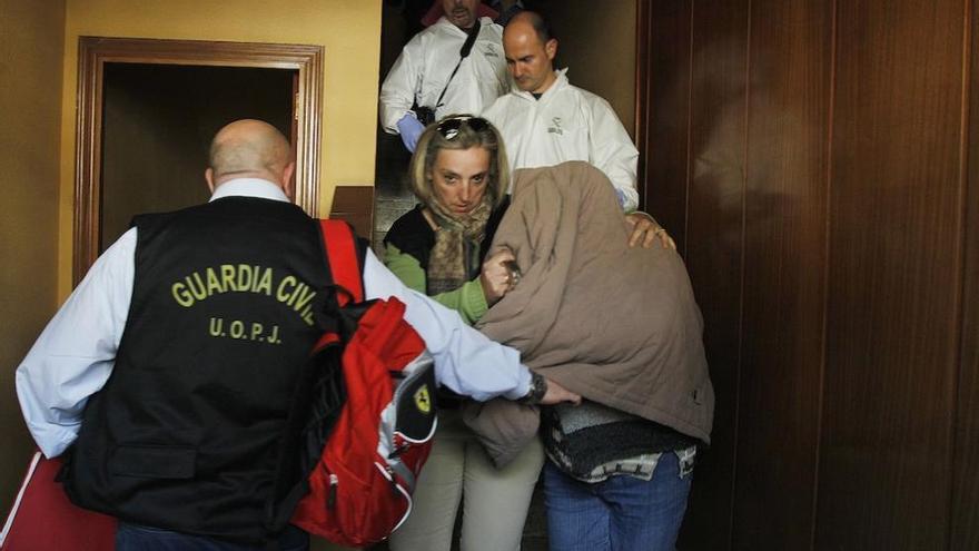 La mujer detenida, conducida por agentes de la Guardia Civil en el interior de la vivienda.