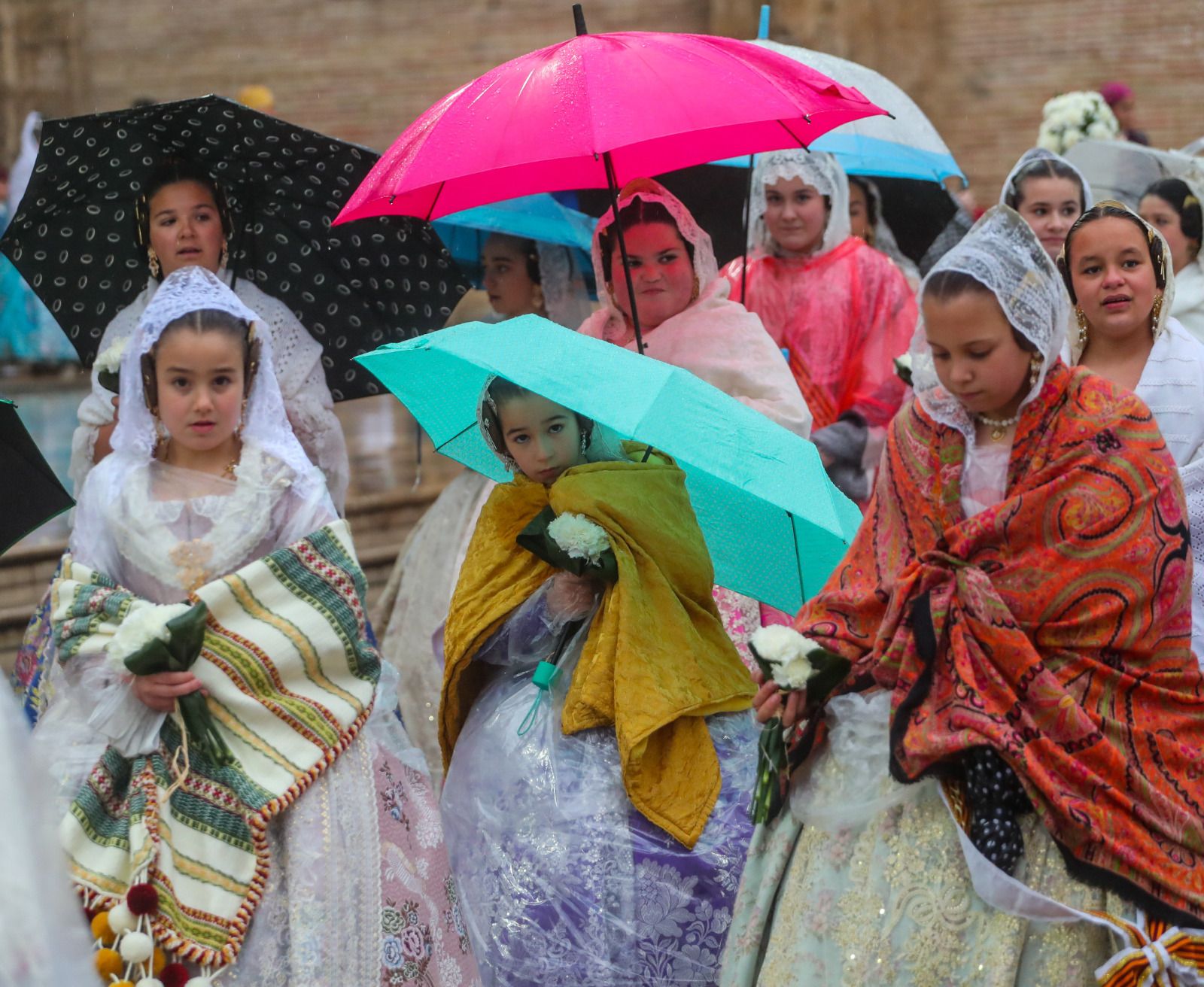 Desfile de chubasqueros y paraguas ante la Mare de Déu