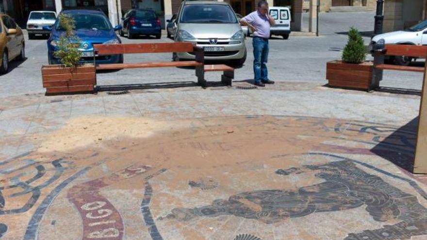 Un hombre observa los daños ocasionados con pintura, posiblemente de caucho, durante la noche.