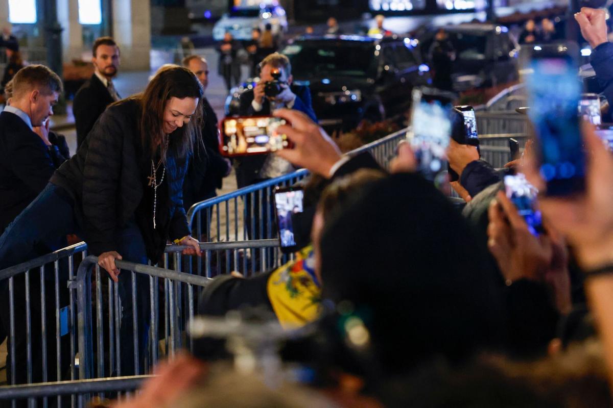 La premio Nobel de la paz, Maria Corina Machado, saluda a los partidarios reunidos fuera del Gran Hotel en Oslo, Noruega, a principios del 11 de diciembre de 2025. Machado llegó a Oslo horas después de que el premio de la líder de la oposición venezolana fuera recogido en su nombre por su hija. (Foto de Odd ANDERSEN / AFP)