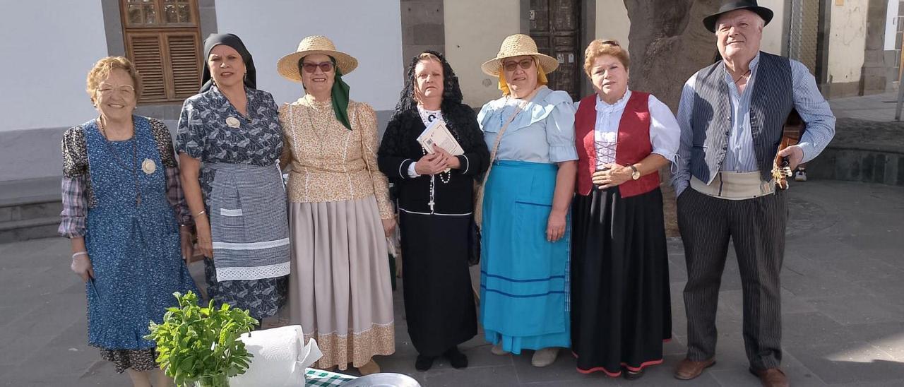 Componentes de la asociación Roque Azucarero durante la celebración de las últimas fiestas, con algunos de sus platos al frente.