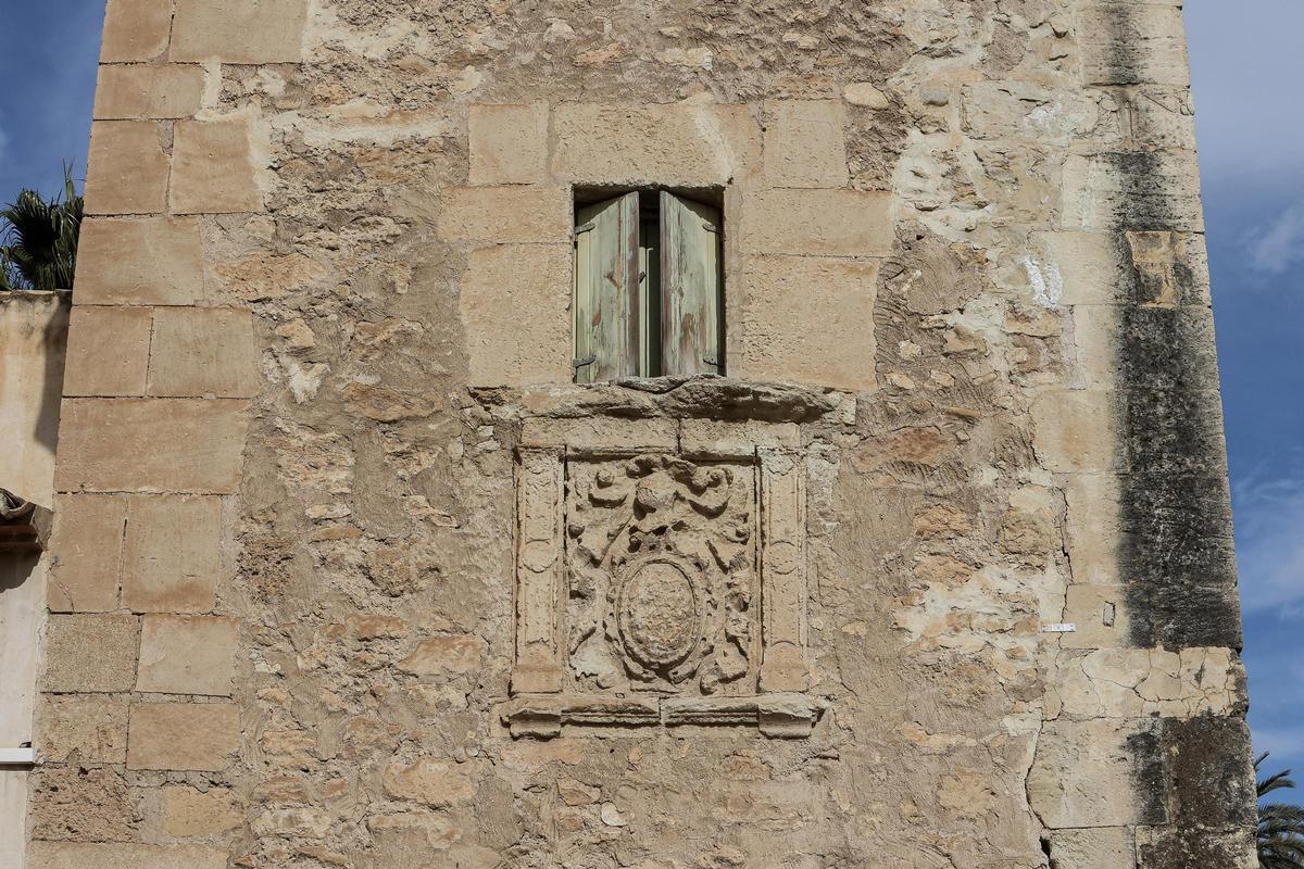 Una ventana abierta de la fachada sobre el escudo heráldico de la torre vigía de Ressemblanc