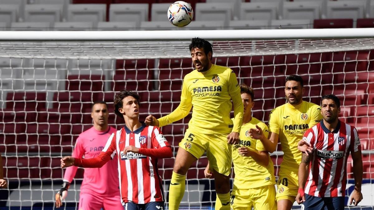 Parejo despeja un balón ante Joao Félix y Suárez.