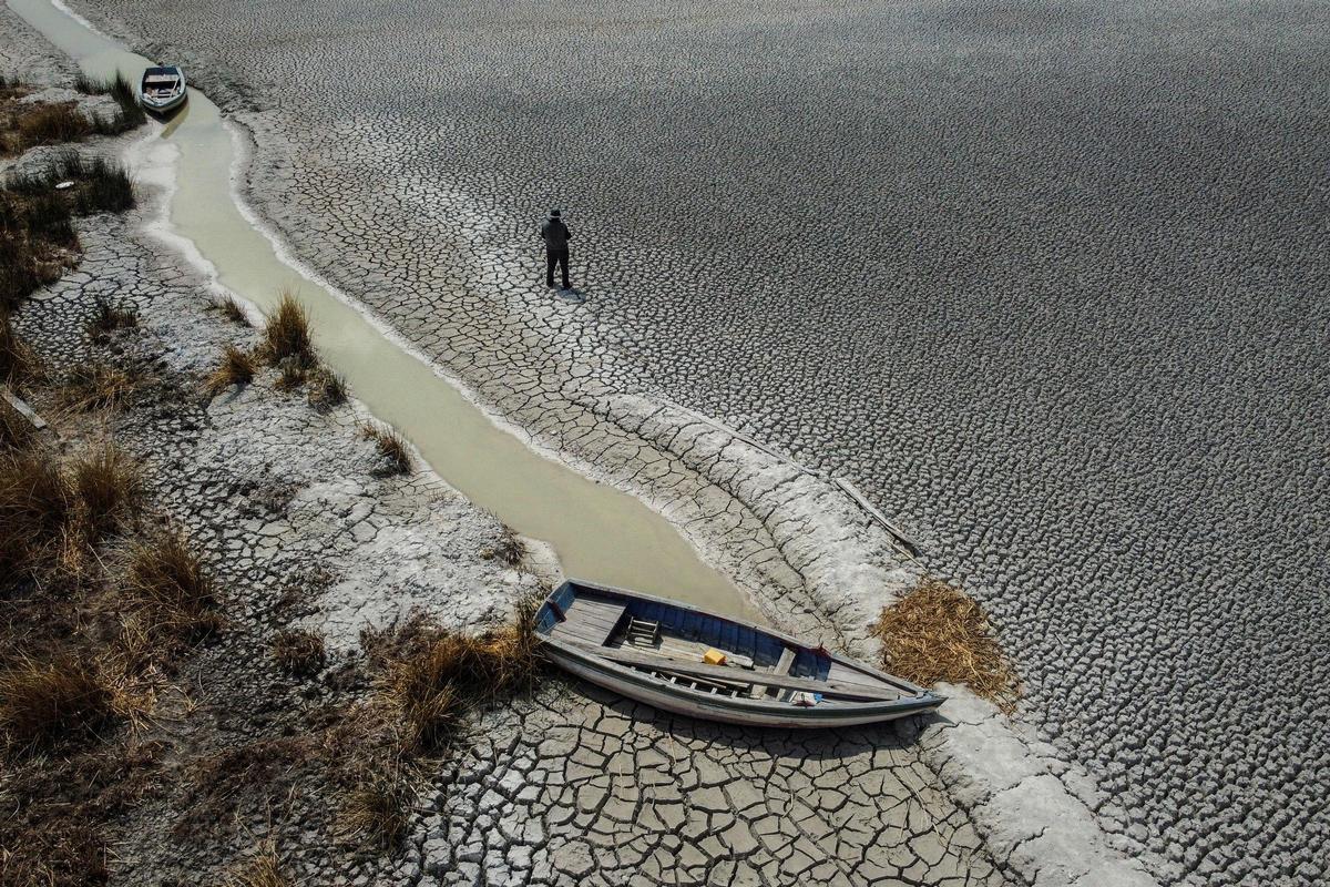 Manuel Flores camina sobre un área seca que muestra la caída en el nivel del lago Titicaca, la cuenca de agua dulce más grande de América Latina, a medida que se acerca a niveles récord, en la isla Cojata, Bolivia, el 26 de octubre de 2023.