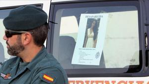 Un guardia civil con la foto que se ha distribuido de Diana Quer.