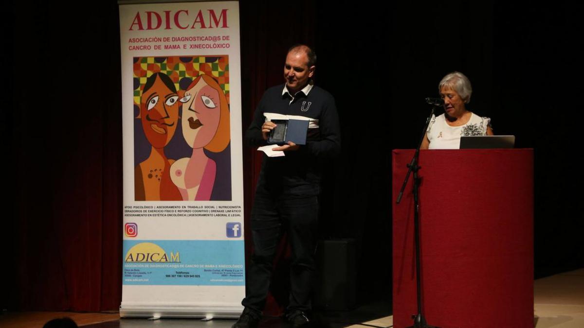 Eduardo González recibe el galardón de manos de la presidenta de Adicam, Olga Sotelo.