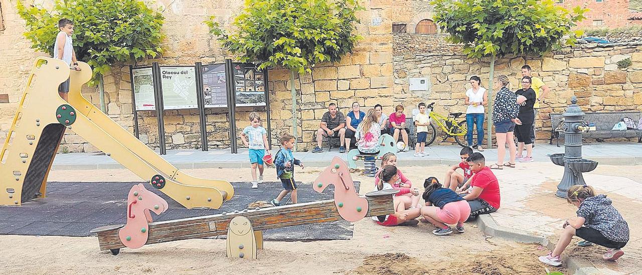 Un grupo de niños juega en la zona infantil de un parque de Olocau del Rey, que en septiembre perderá un profesor.