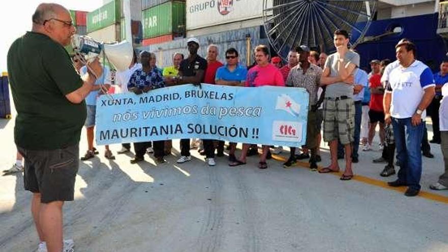 Marineros y sindicalistas, con una pancarta ante el barco.  // I. Abella