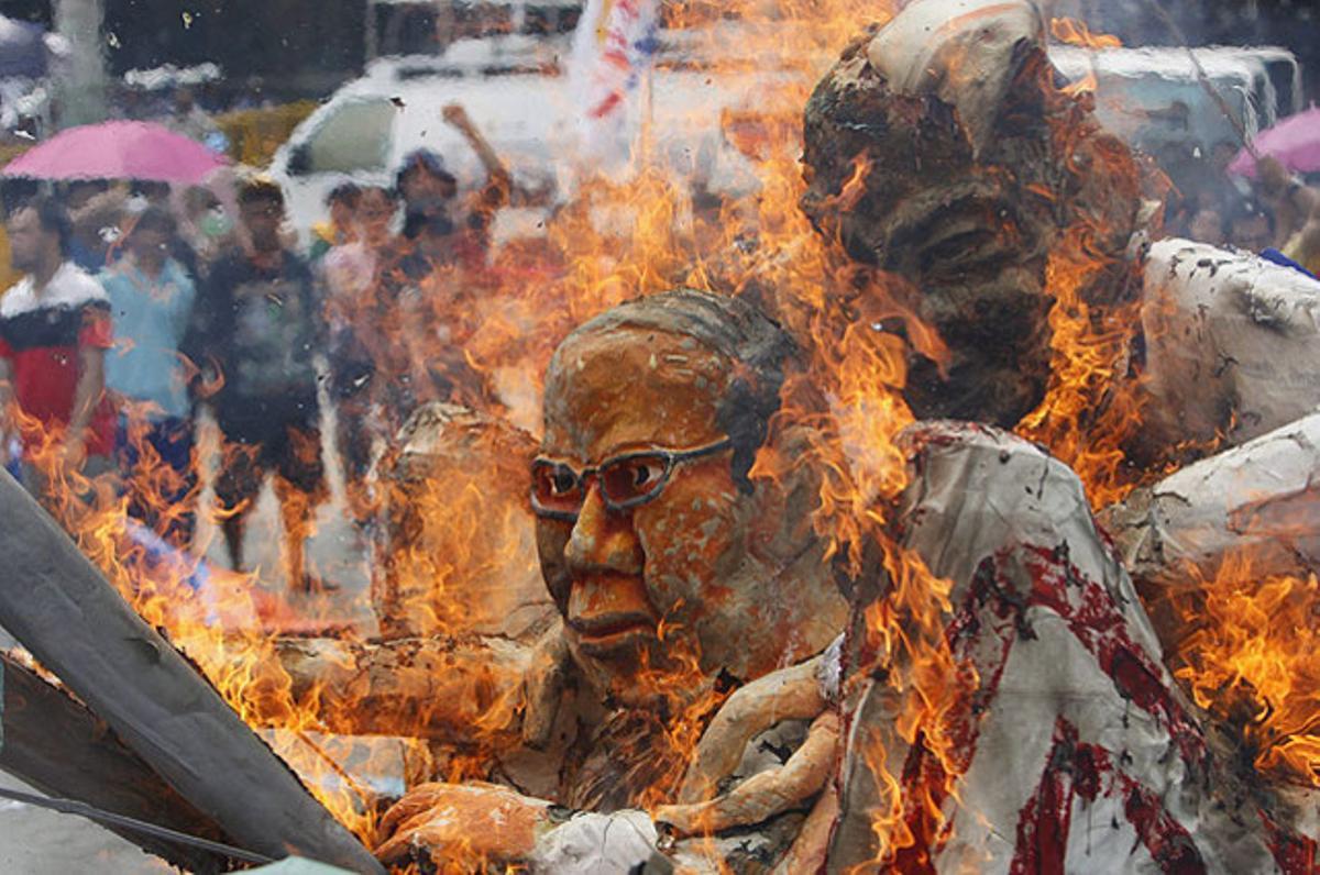 Els manifestants cremen efígies del president filipí, Benigno Aquino, i de l’’Oncle Sam’, durant una protesta a Manila (Filipines).
