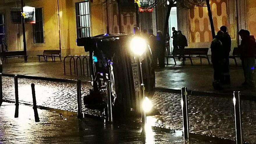 El vehicle bolcat després
d&#039;accidentar-se davant la
seu de la Generalitat.