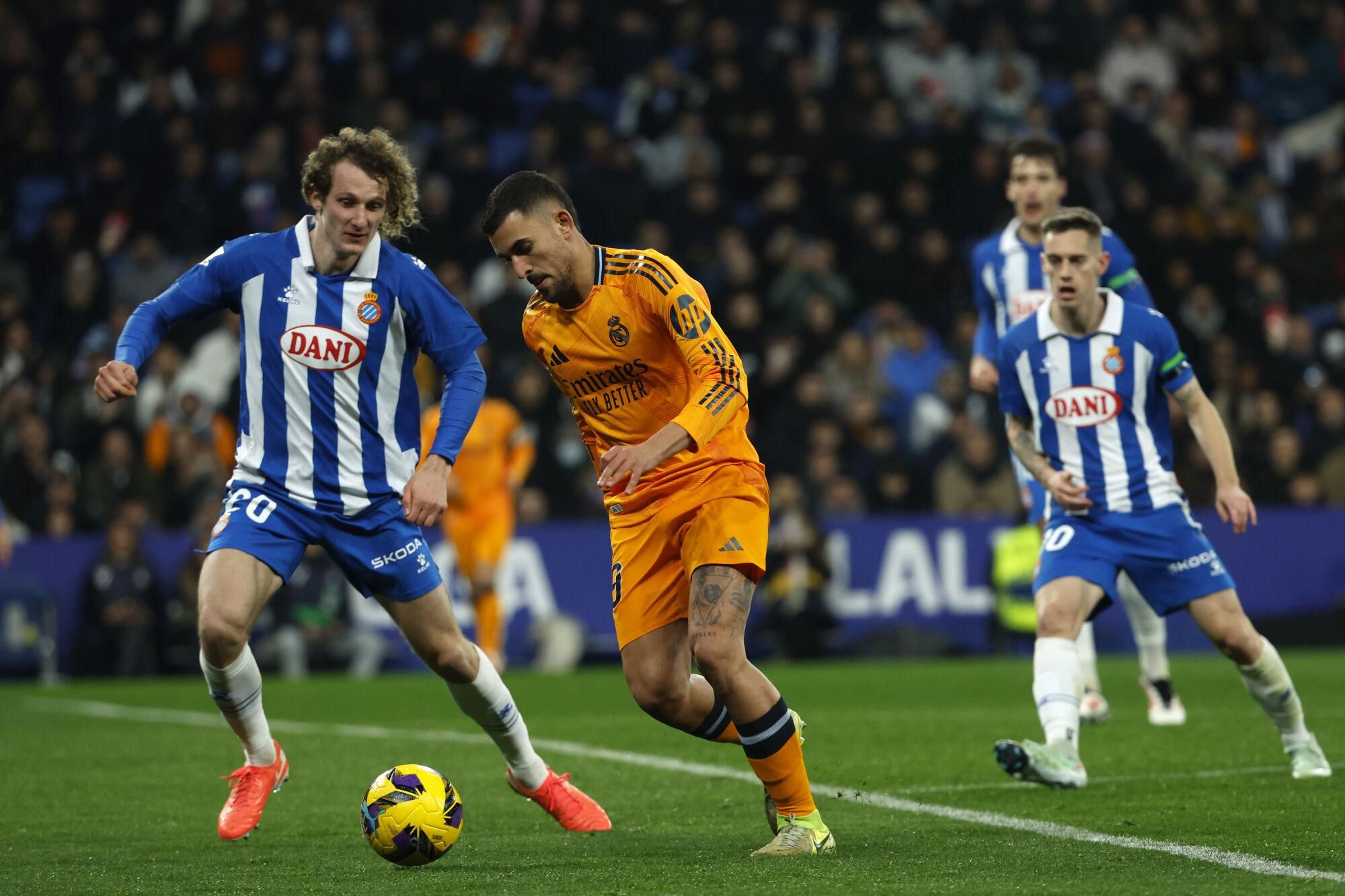 Real Madrid's Dani Ceballos, 2nd left, tries to get past Espanyol's Alex Kral during a Spanish La Liga soccer match between Espanyol and Real Madrid at the Lluis Companys Olympic Stadium in Barcelona, Spain, Saturday Feb.1, 2025. (AP Photo/Joan Monfort)