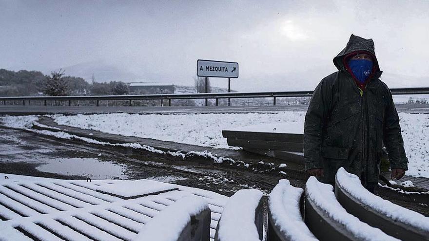 Un hombre camina protegido del frío y la nieve en el muncipio de A Mezquita. // Brais Lorenzo