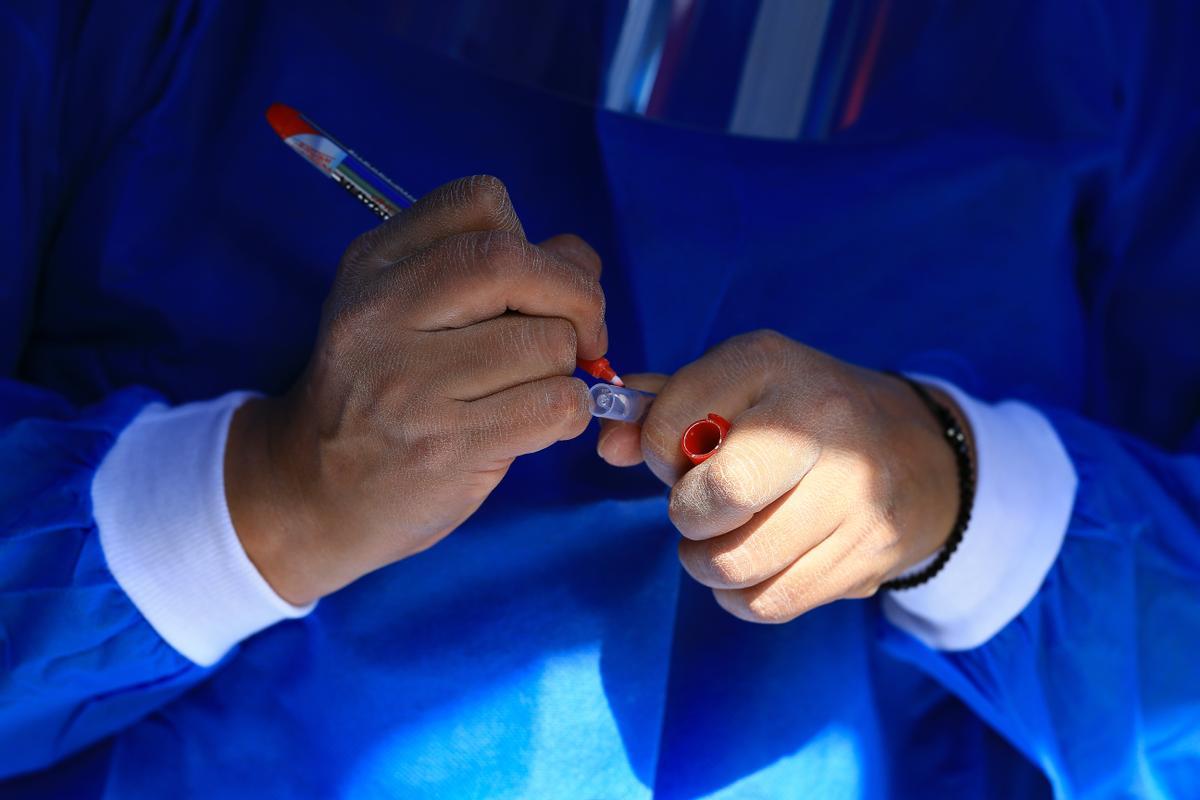 Un sanitario maneja una muestra con pruebas de coronavirus.