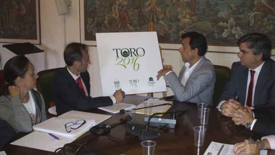Autoridades provinciales y locales observan el logotipo elaborado para respaldar la candidatura de Toro.