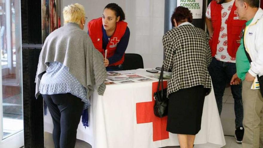Un grupo de personas se interesa por la campaña de captación de socios de Cruz Roja.