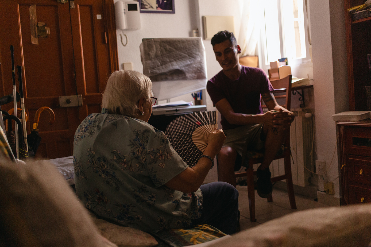 Pilar Pérez se abanica junto a su voluntario, Carlos Albarracín, en su casa de Madrid.