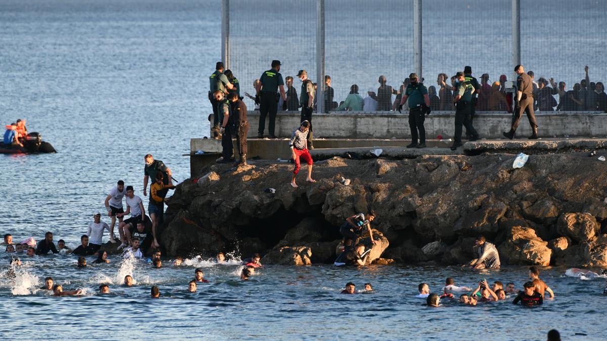 Miles de inmigrantes han entrado este lunes a nado en Ceuta bordeando el espigón del Tarajal.