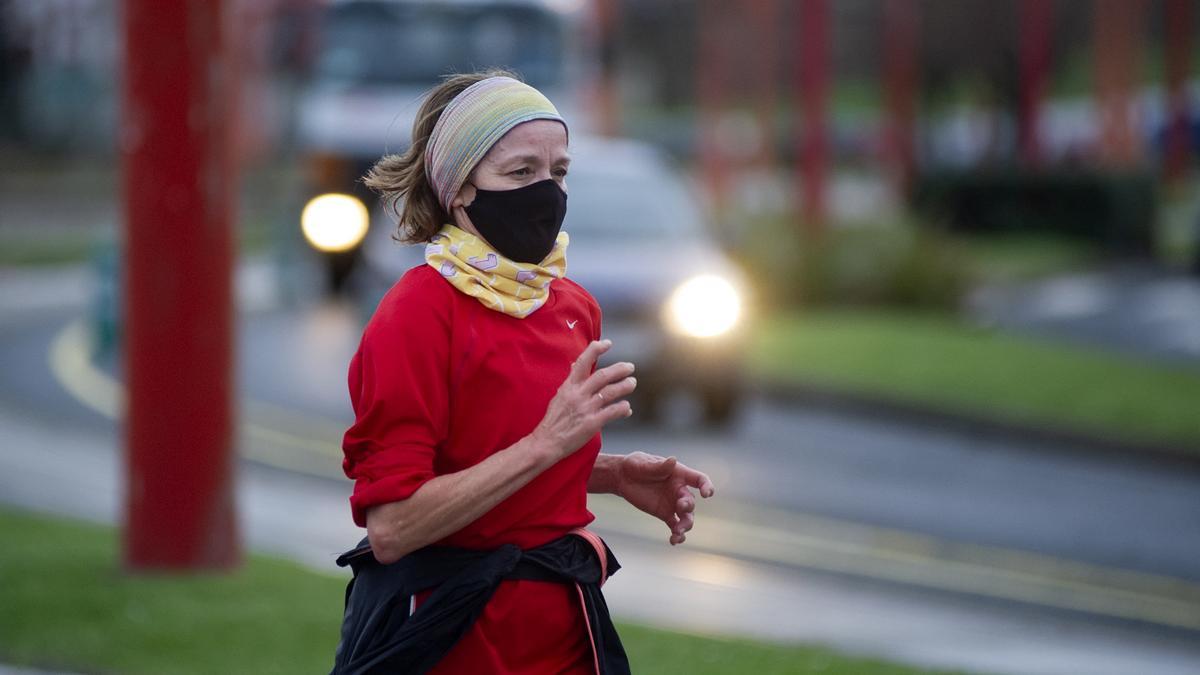 Una persona corre en solitario y con mascarilla.