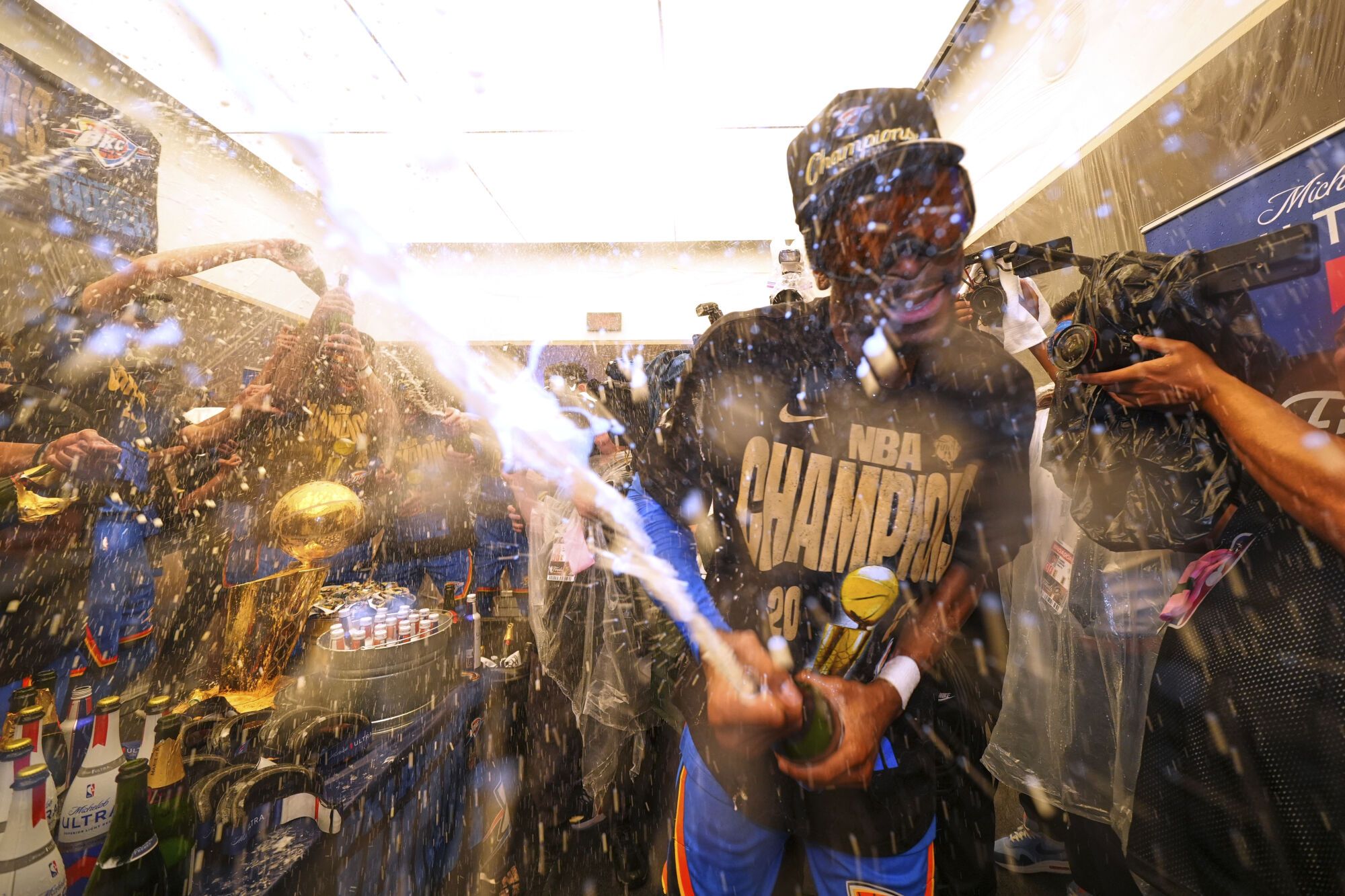 Oklahoma City Thunder guard Shai Gilgeous-Alexander celebrates with teammates in the locker room after winning the NBA basketball championship with a Game 7 victory against the Indiana Pacers Sunday, June 22, 2025, in Oklahoma City. (AP Photo/Julio Cortez)