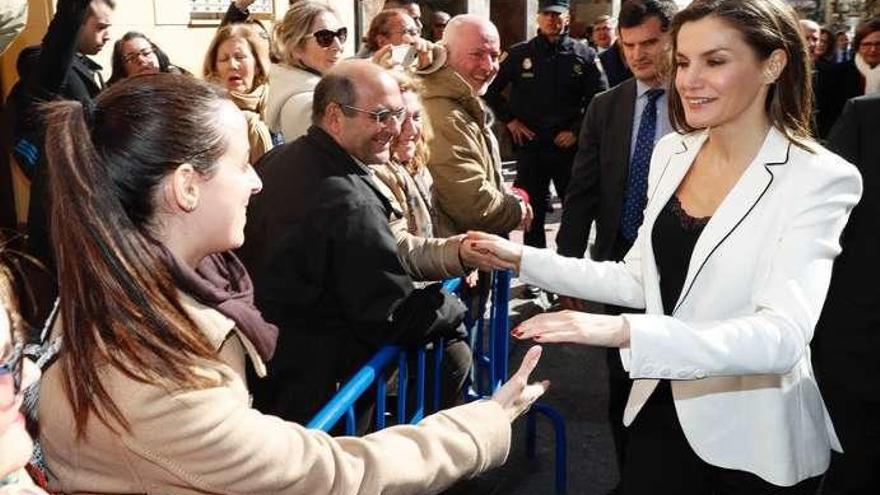 La Reina Letizia saluda a vecinos de Gerona. A la derecha, durante la reunión del jurado.